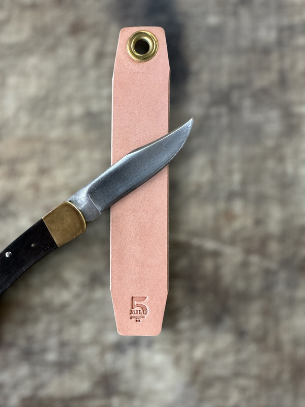 Knife with a pink sheath on a textured surface