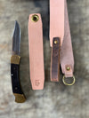 Knife with leather sheathes on a textured surface