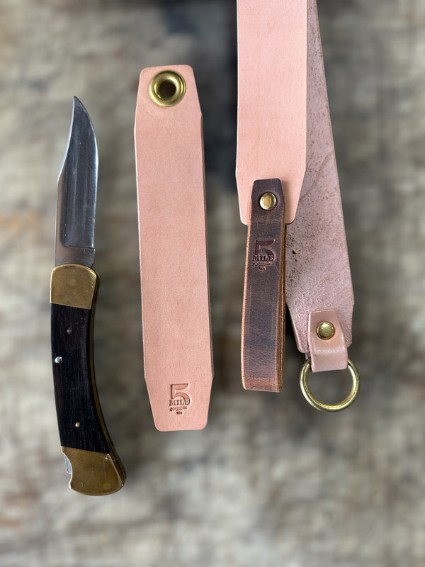 Knife with leather sheathes on a textured surface