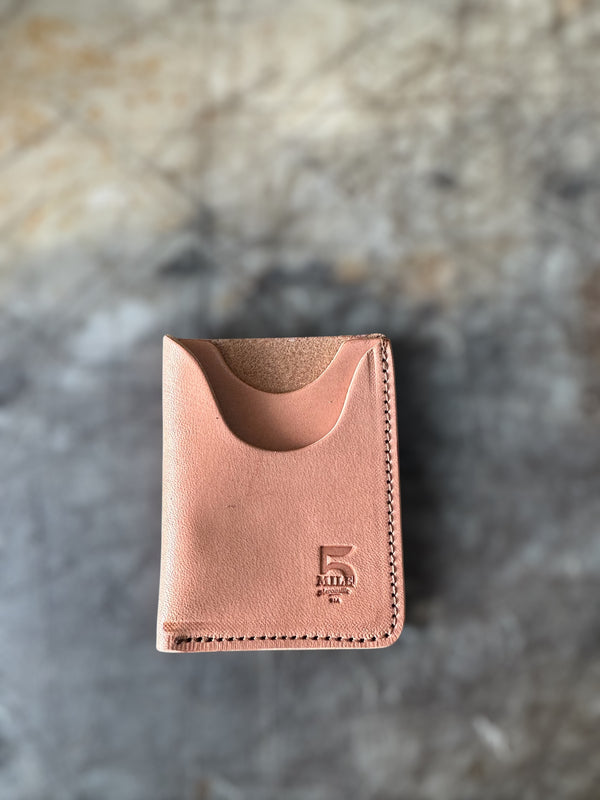 Brown leather wallet with a brand logo on a textured surface