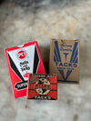 Three vintage tack boxes with different brands on a textured surface