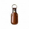 A brown leather keychain pouch with brass hardware, holding a silver and cream pocket knife, shown against a plain white background.