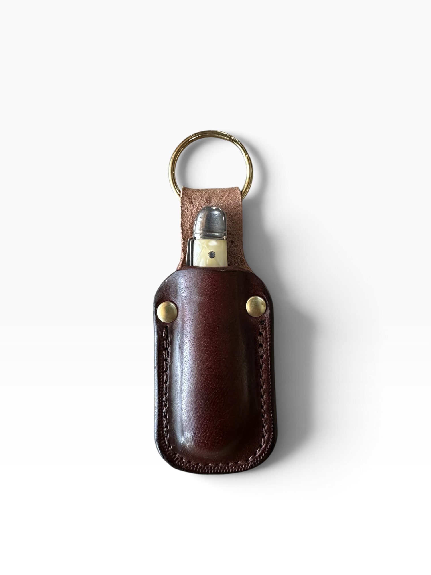 A dark brown leather keychain sheath holding a silver and gold lighter, attached to a brass key ring, shown on a clean white background.